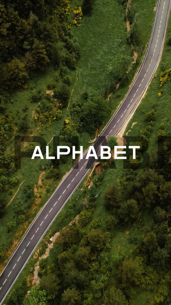 Carte de vœux 2025 d’Alphabet : route vue du ciel à travers une forêt, nom Alphabet en lettres blanches
